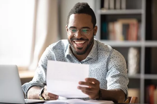 Man Smiling at Paper